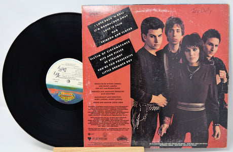 Vinyl record with a colorful label and a cover featuring four people on a red background.