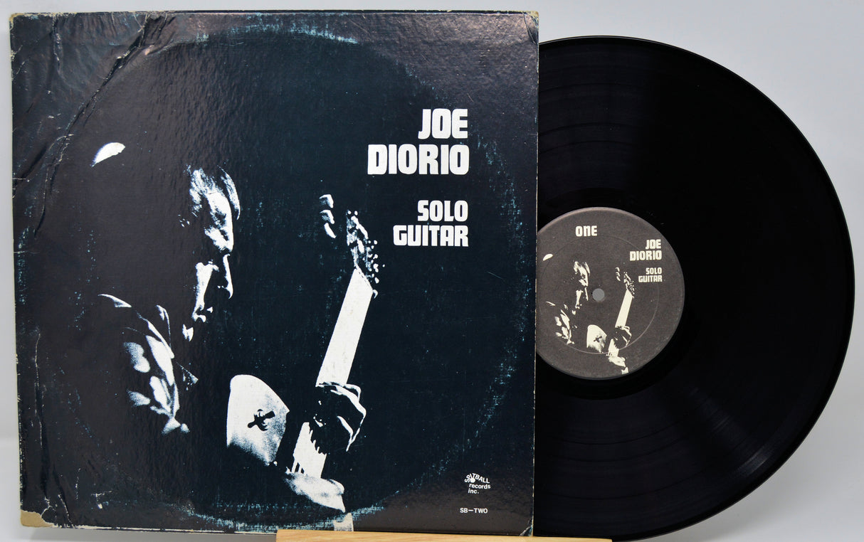 Vinyl record and cover with 'Joe Diorio Solo Guitar' on a gray background