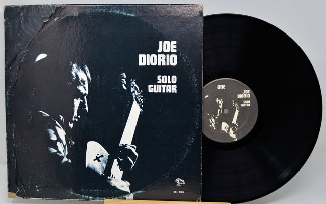 Vinyl record and cover with 'Joe Diorio Solo Guitar' on a gray background