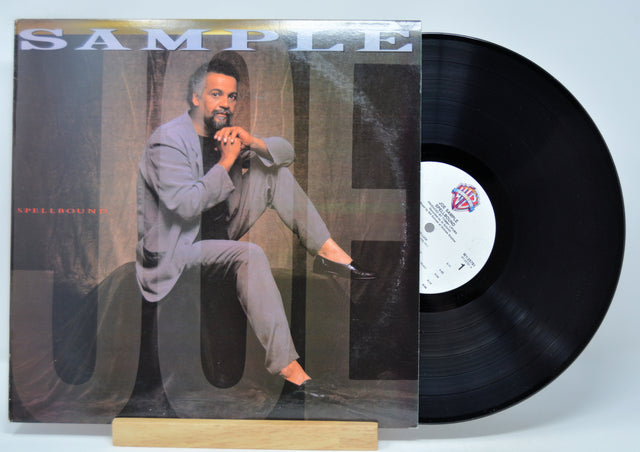 'Joe Sample Spellbound' Vinyl record with a cover featuring a man sitting on a chair, on a light blue background.