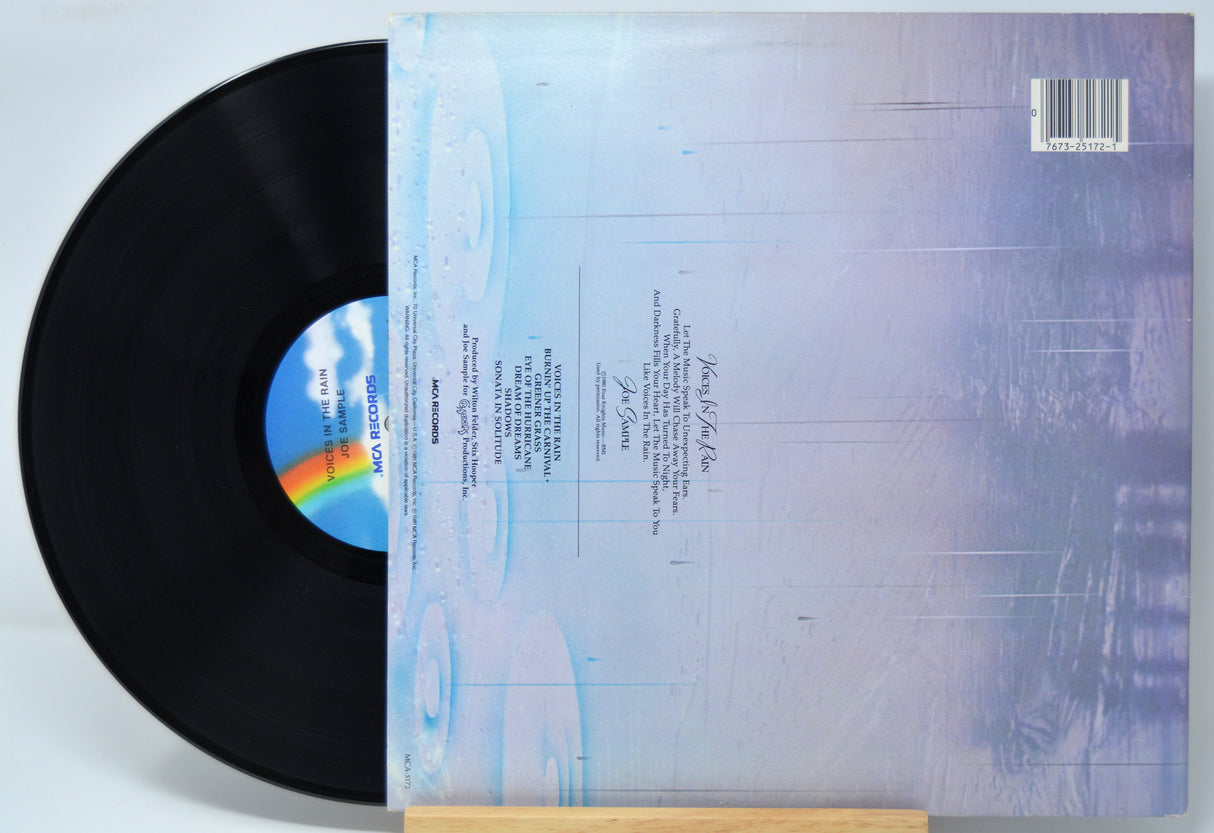 'Joe Sample Voices In The Rain' Vinyl record with cover displaying text and a rainbow symbol on a light blue background