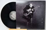 Joe Walsh 'Smoke' vinyl record LP with the black vinyl disc partially visible next to the printed album cover, which features a black and white photo of the musician playing an electric guitar on a stool.