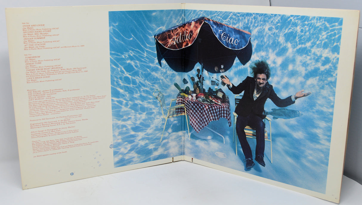 Album cover with a person in a suit and hat, and a parachute, set against a blue sky.