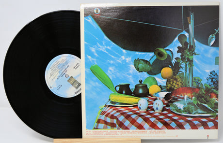 Vinyl record with a colorful cover featuring a table setting and space-themed elements.