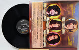 A vinyl record and its printed sleeve for Joe Vitali's 'Rockin' at the Palace' are displayed side by side on a light surface. The black record is partially visible behind the sleeve, which features four circular portrait photos of the performers and track listing text.