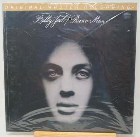 Billy Joel x Rino Man 'Original Master Recording' vinyl record sleeve, sealed in plastic shrink wrap, displayed on a wooden stand.