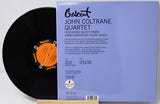 Vinyl record album cover and part of the black record sleeve displayed on a wooden stand. The cover reads 'Crescent John Coltrane Quartet' with track listing and artist names, and the record label 'Impulse!' is visible on the orange label and lower left.