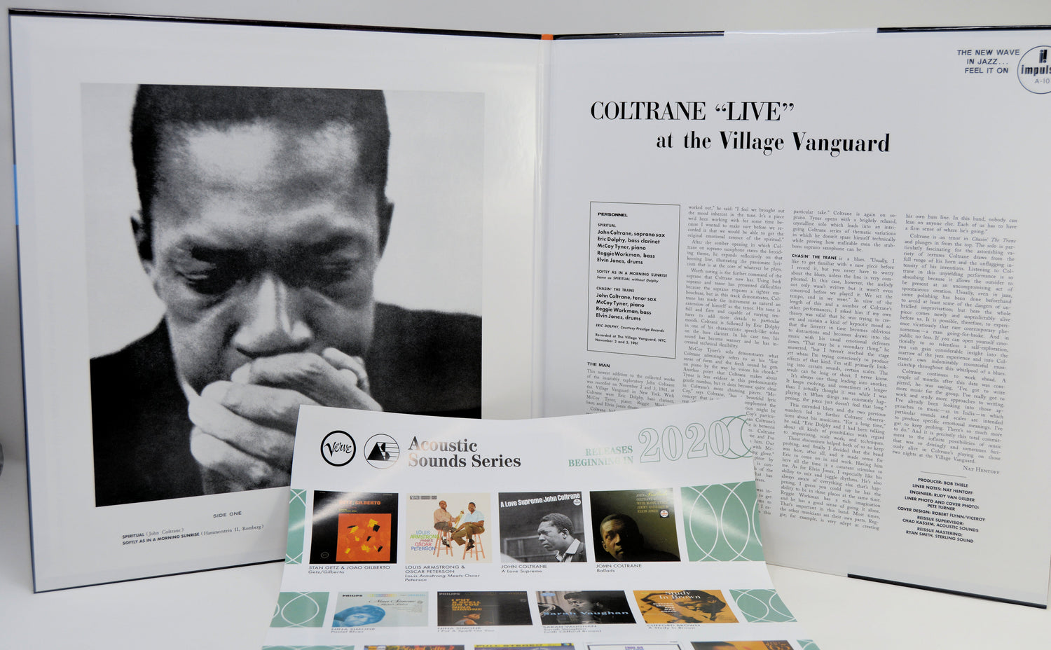 An open gatefold cover showing a black-and-white portrait of Coltrane on the left page and an article titled 'COLTRANE "LIVE" at the Village Vanguard' on the right page, with a printed program or booklet placed in front.