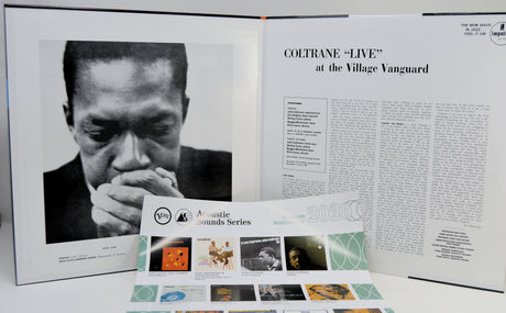 An open gatefold cover showing a black-and-white portrait of Coltrane on the left page and an article titled 'COLTRANE "LIVE" at the Village Vanguard' on the right page, with a printed program or booklet placed in front.