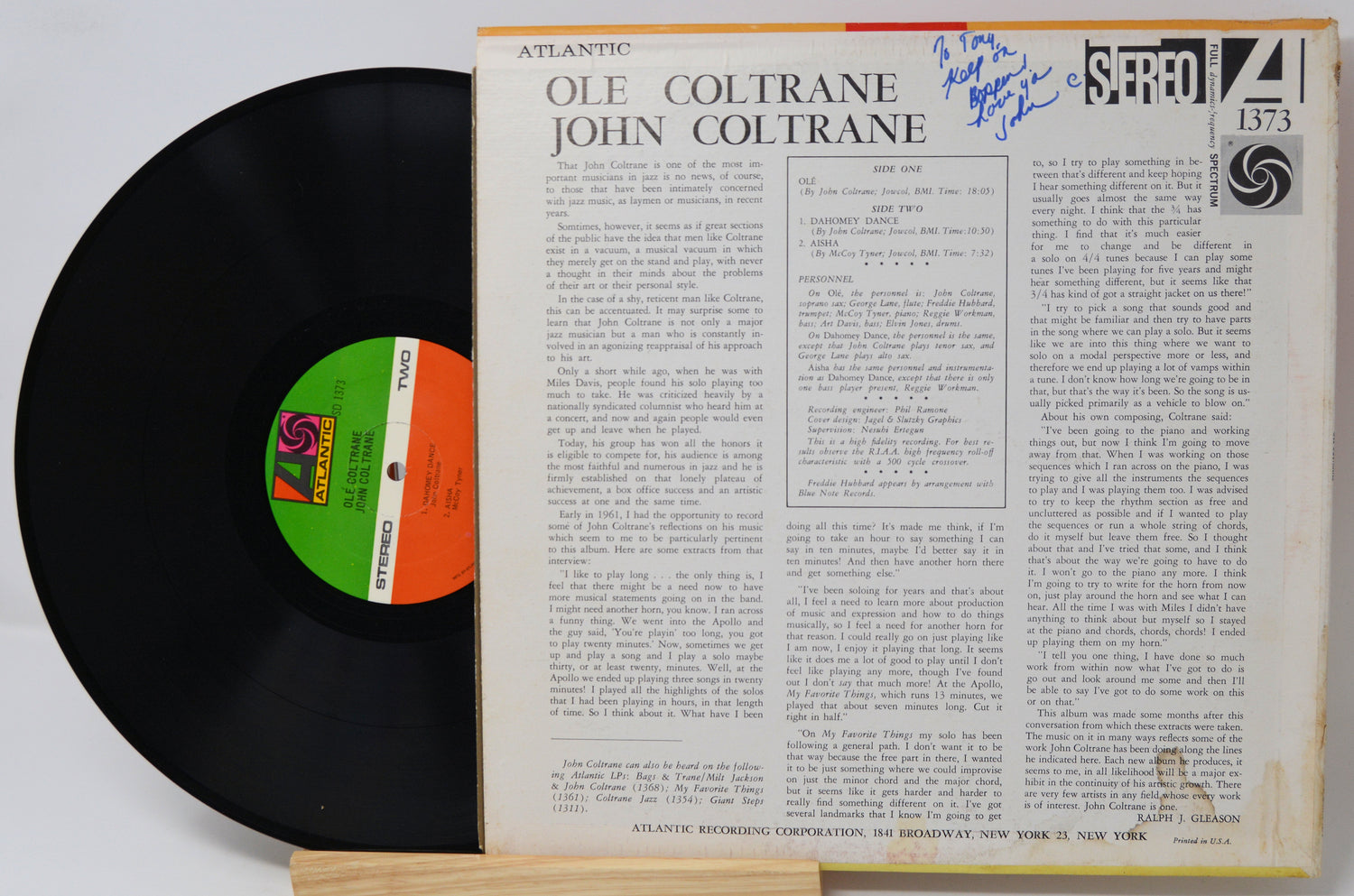 A vinyl record partially pulled from its paper sleeve, showing the black record with a green and orange label next to the printed cover insert for Ole Coltrane's 'Blue Monk' on Atlantic Records.