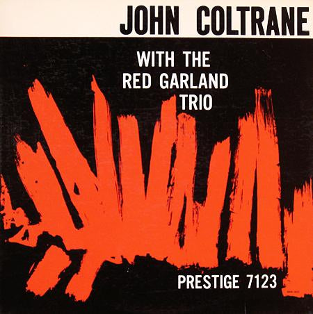 Album cover for 'With the Red Garland Trio' by John Coltrane, featuring bold white text on a black background with a large abstract red brushstroke graphic across the lower half.