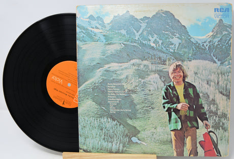 Vinyl record with a mountain-themed cover featuring a person holding a suitcase.