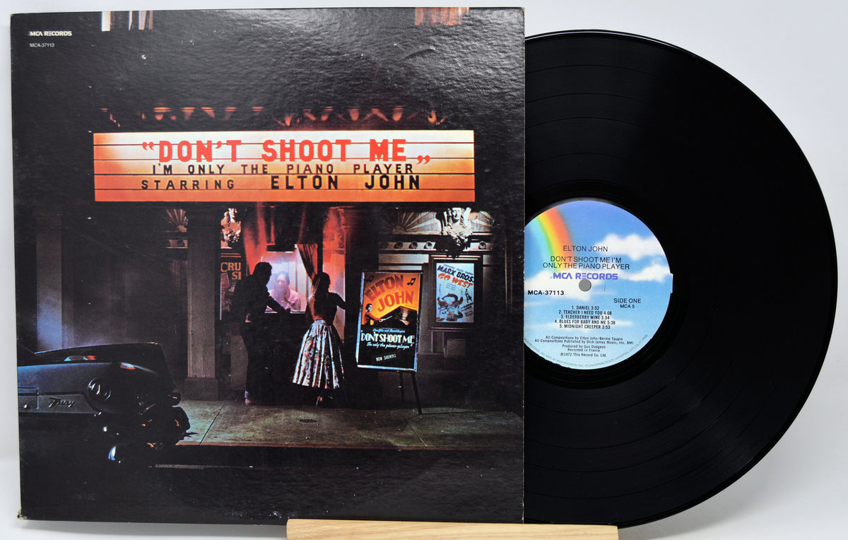 Elton John's 'Don't Shoot Me' vinyl record LP with its illustrated cover jacket and the black record partially pulled out, displayed on a light gray background.