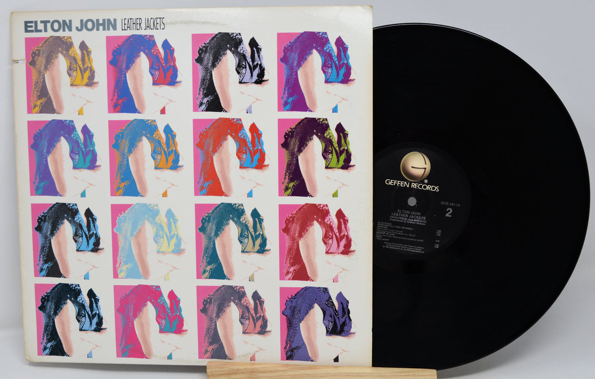 Vinyl record with a colorful cover featuring a grid of images and 'Elton John' branding.