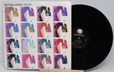 Vinyl record with a colorful cover featuring a grid of images and 'Elton John' branding.