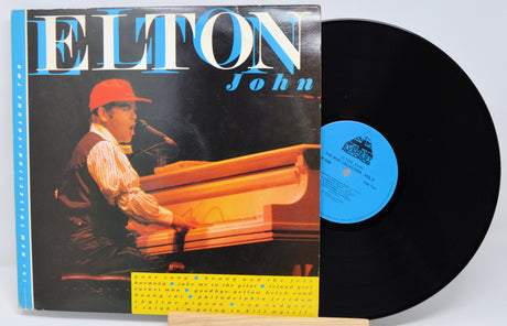 Vinyl record with cover featuring Elton John playing piano, on a white background