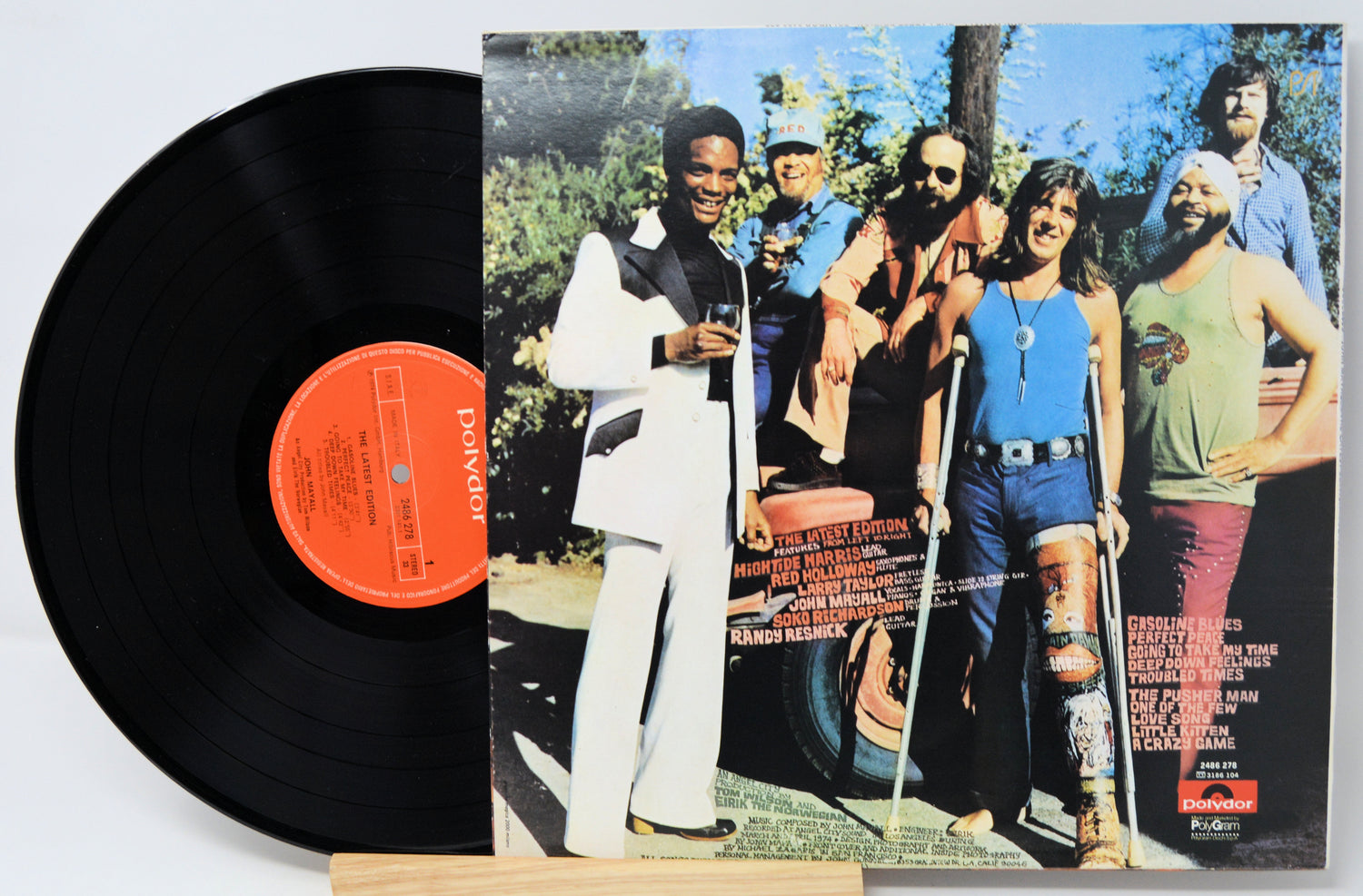 Vinyl record with a colorful album cover featuring a group of people outdoors.
