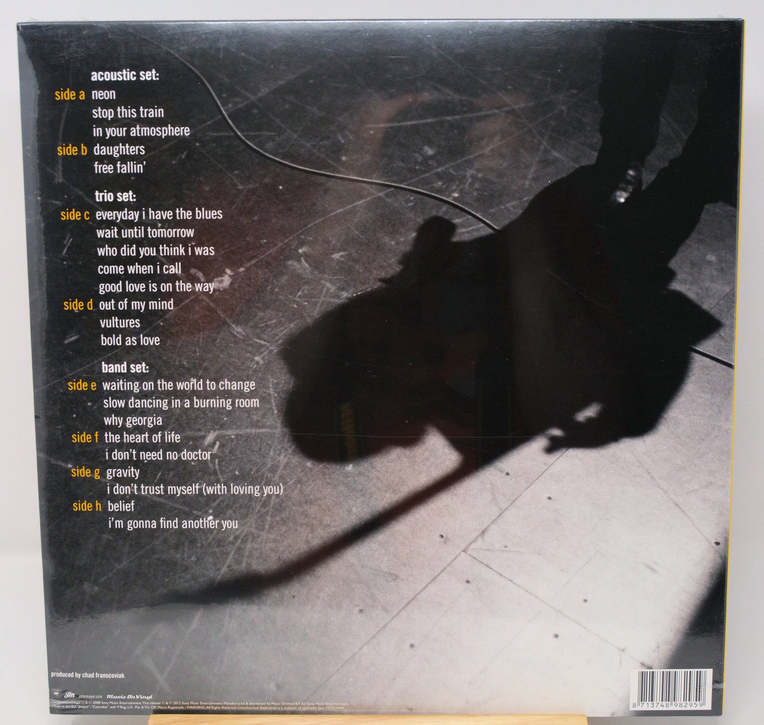 The back cover of a vinyl record sleeve for the acoustic set of Bob Dylan's 'The Freestanding Man'. The cover features a dark, moody photograph of a person holding a guitar, casting a long shadow on a concrete floor.