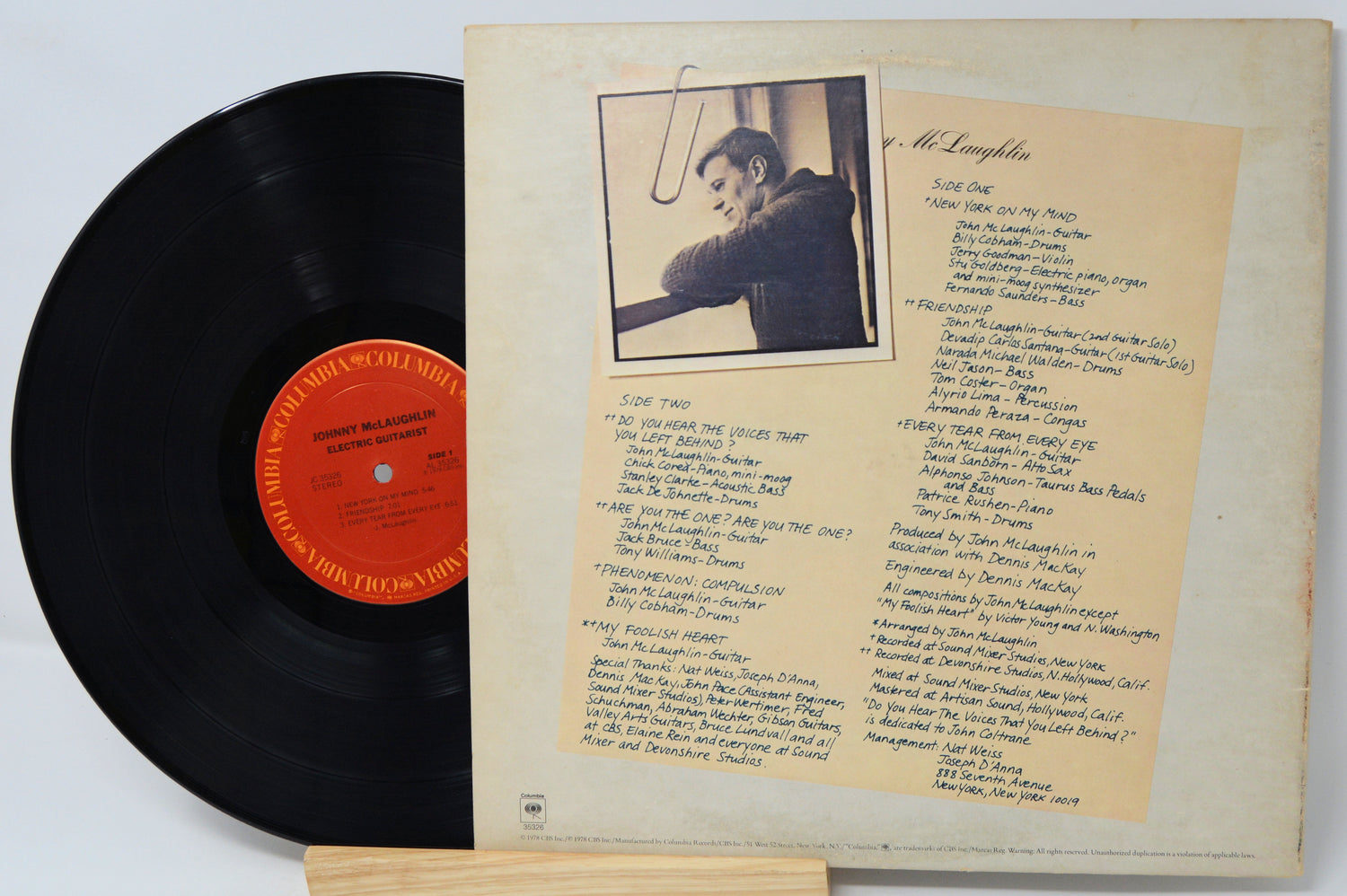 Vinyl record with cover featuring a photo and text on a light gray background