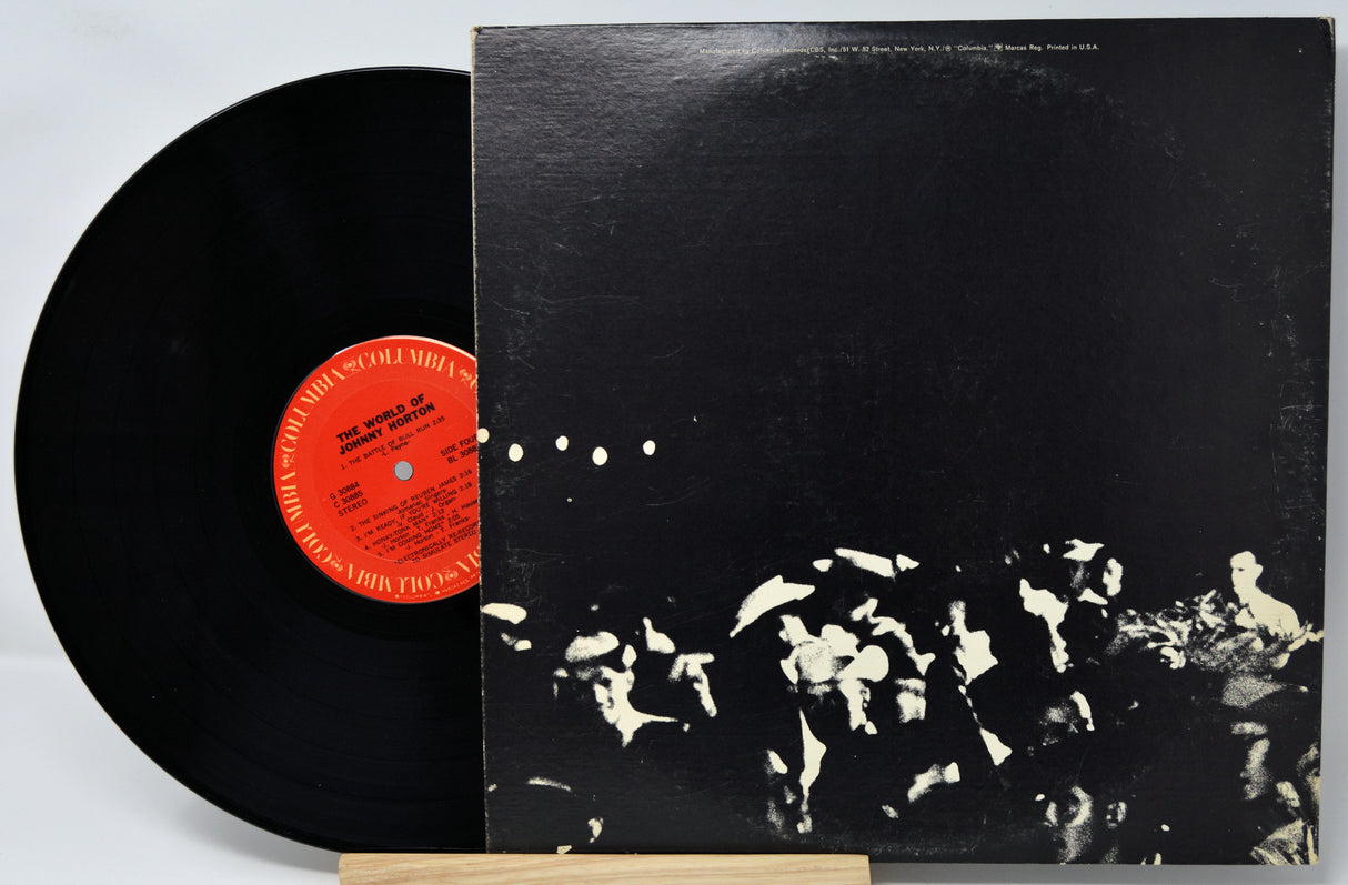 Vinyl record with a black and white cover and red label on a light gray background