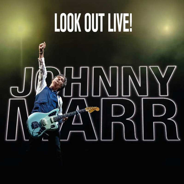Johnny Marr performing live on stage with guitar under 'Look Out Live!' banner