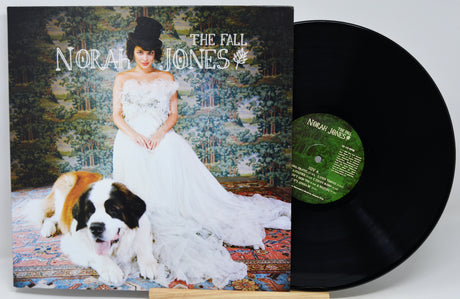 Norah Jones 'The Fall' vinyl record LP with its album cover in front of the black record, photographed on a light gray background.