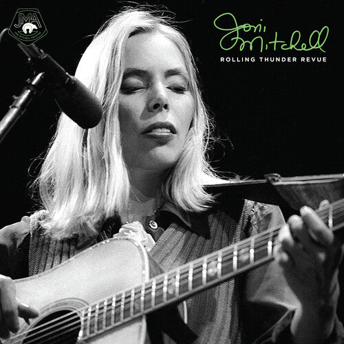 Joni Mitchell performing live on stage with acoustic guitar during Rolling Thunder Revue