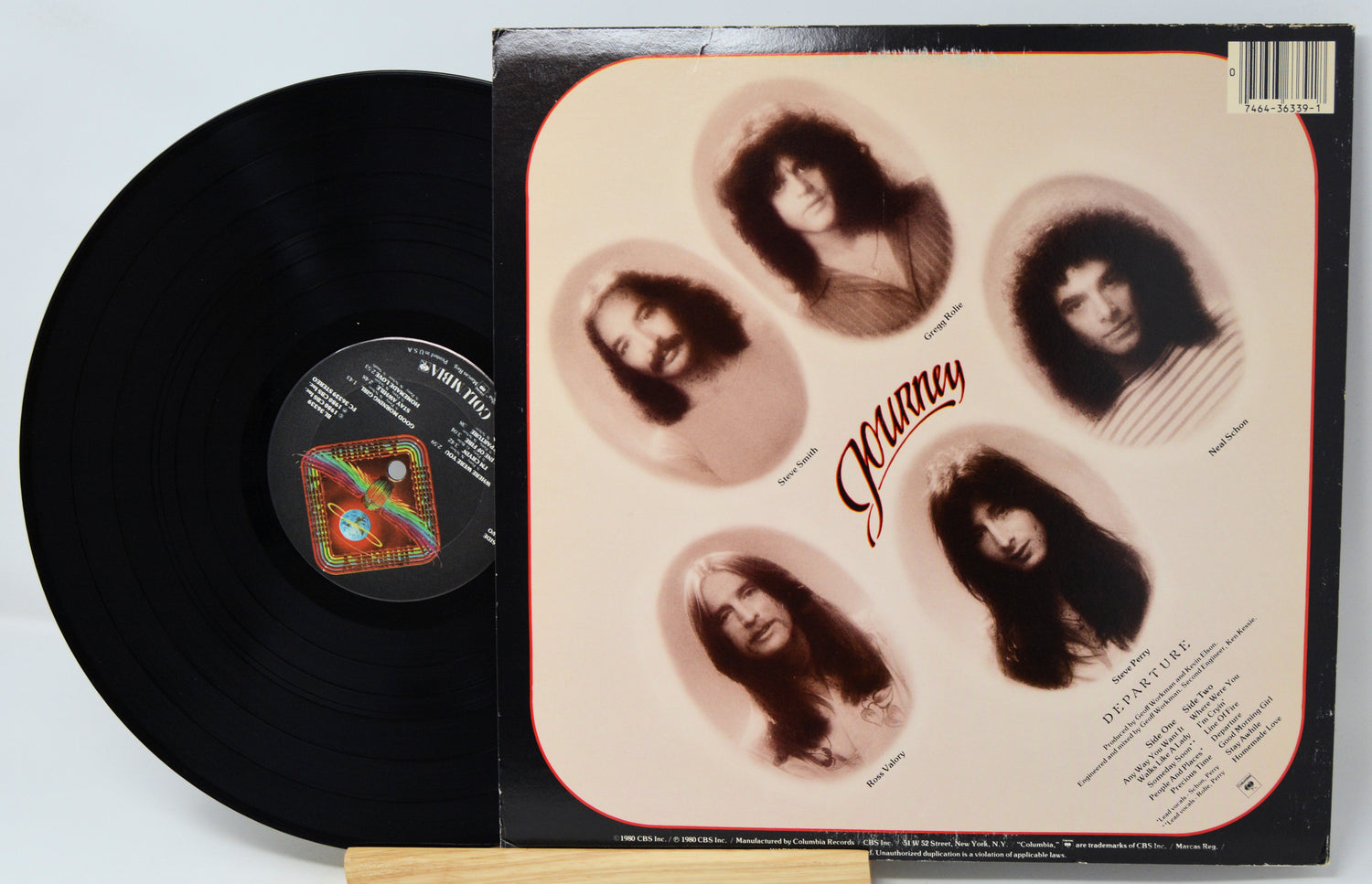 A vinyl record partially pulled from its sleeve, showing the black record on the left and the album cover on the right. The cover features five sepia-toned oval portraits with the title 'Jazzman' in red script on a cream background.