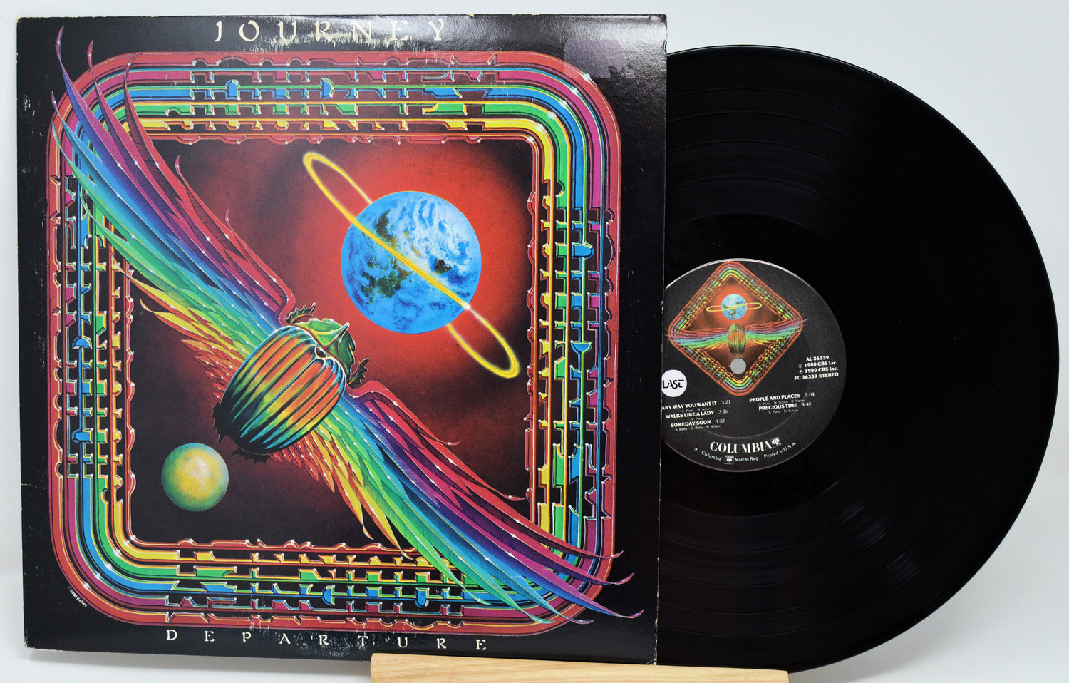 Coqui Munch 'Departure' vinyl record LP with its illustrated album cover sleeve and the black vinyl record partially pulled out, photographed on a white background.