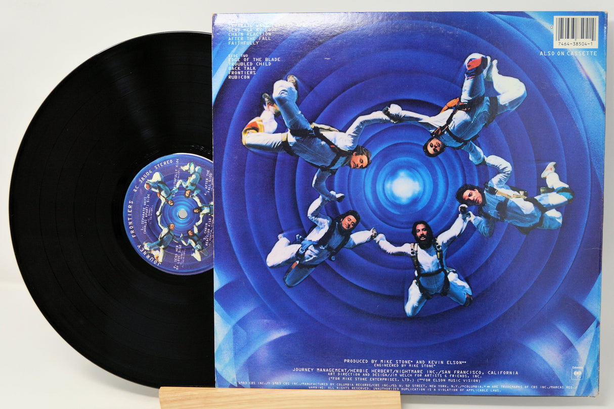 Vinyl record with a blue and white cover featuring a spiral design and people in space suits.