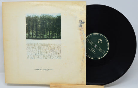 Vinyl record with a yellowed cover featuring text and images, on a light gray background.