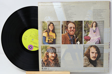 Vinyl record with a colorful cover featuring portraits of people