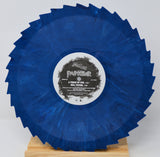 A circular blue marbled vinyl record with jagged outer edges, displayed upright on a small wooden stand against a light gray background. The center label reads 'Panther - A Touch of Evil'.