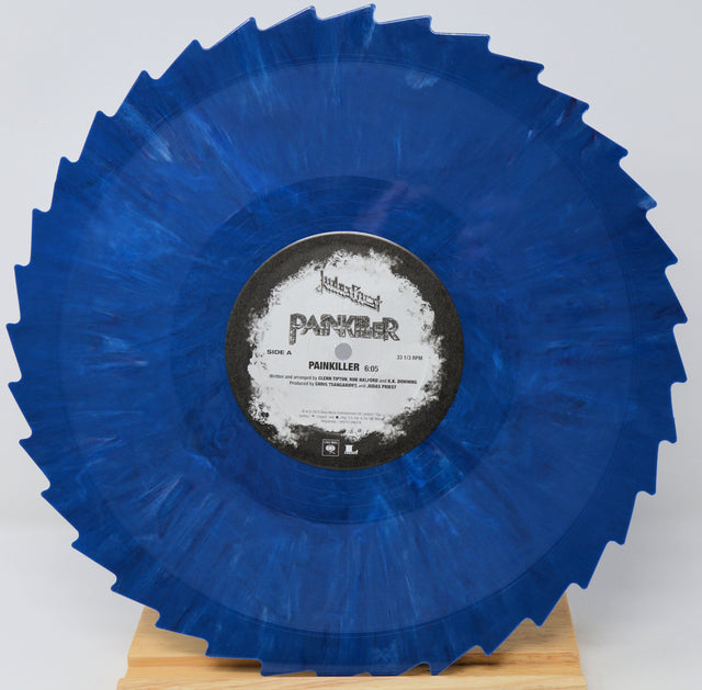 A blue marbled vinyl record with a jagged outer edge, displayed on a small wooden stand against a light gray background. The center label reads 'PANKER' and 'PAINKELLER'.