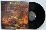 Judas Priest 'Sad Wings of Destiny' vinyl record LP with the illustrated album cover sleeve and a black record partially visible, photographed against a light gray background.