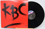 Vinyl record with a red cover featuring 'KBC' and a black record on a white background