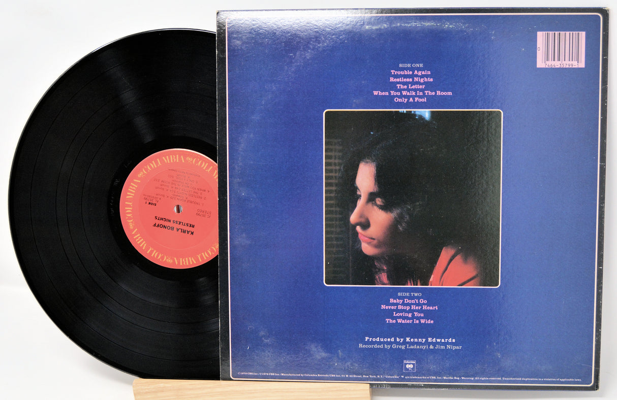 Vinyl record with blue cover featuring a portrait and red label on a white background