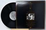 Vinyl record with cover displaying text and a photo on a light gray background
