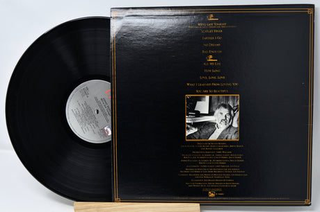 Vinyl record with cover displaying text and a photo on a light gray background