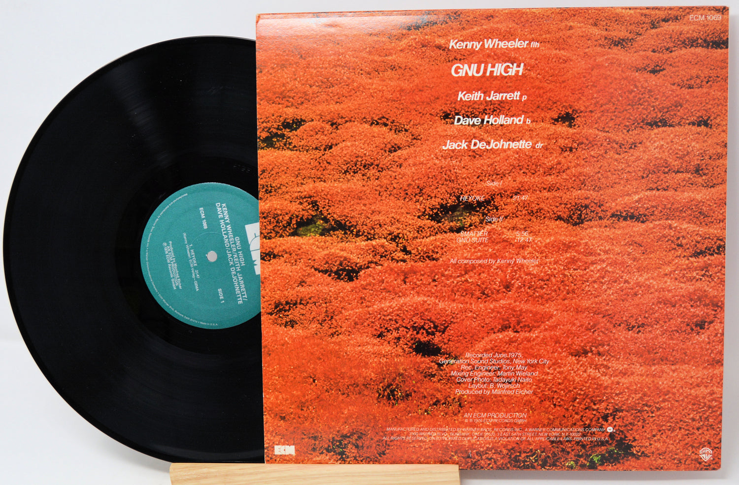 Vinyl record with cover displaying tracklist on a light gray background