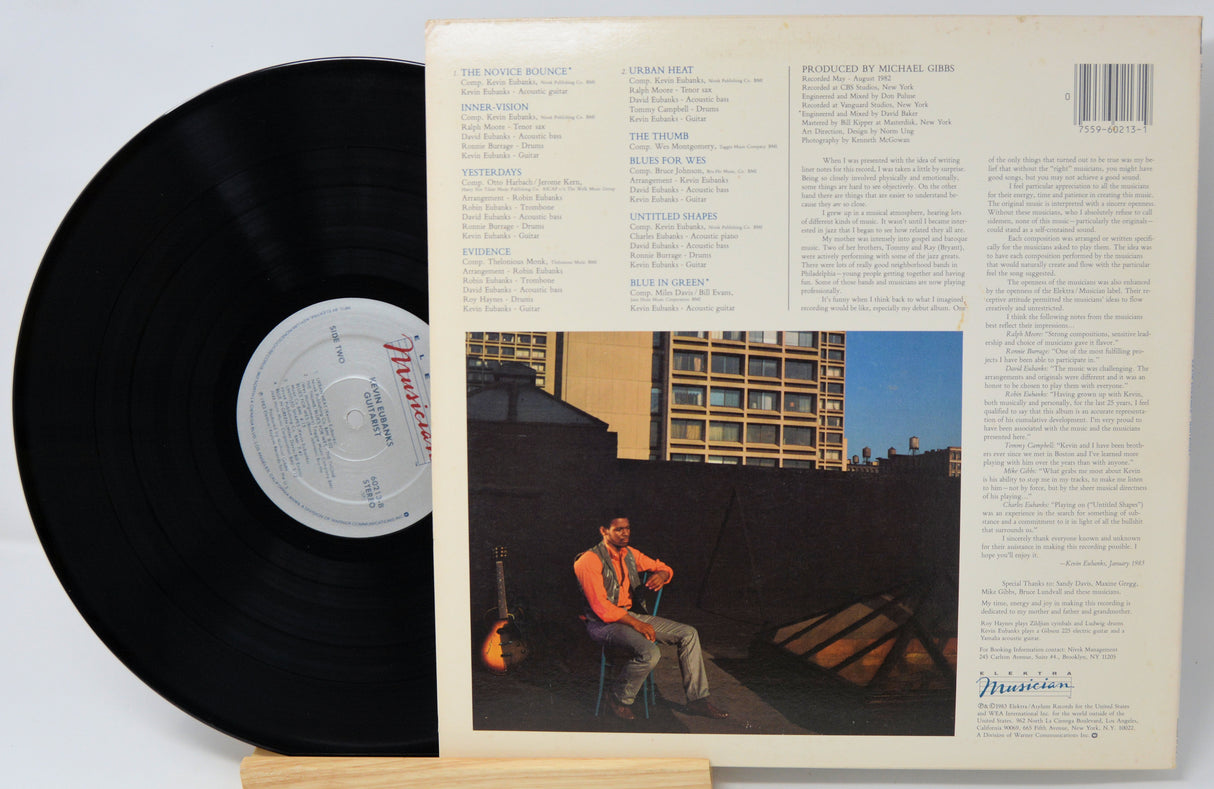 Vinyl record with cover featuring a person on a rooftop and building in the background