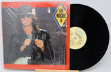 Vinyl record with a cover featuring a person and a prominent label on a white background
