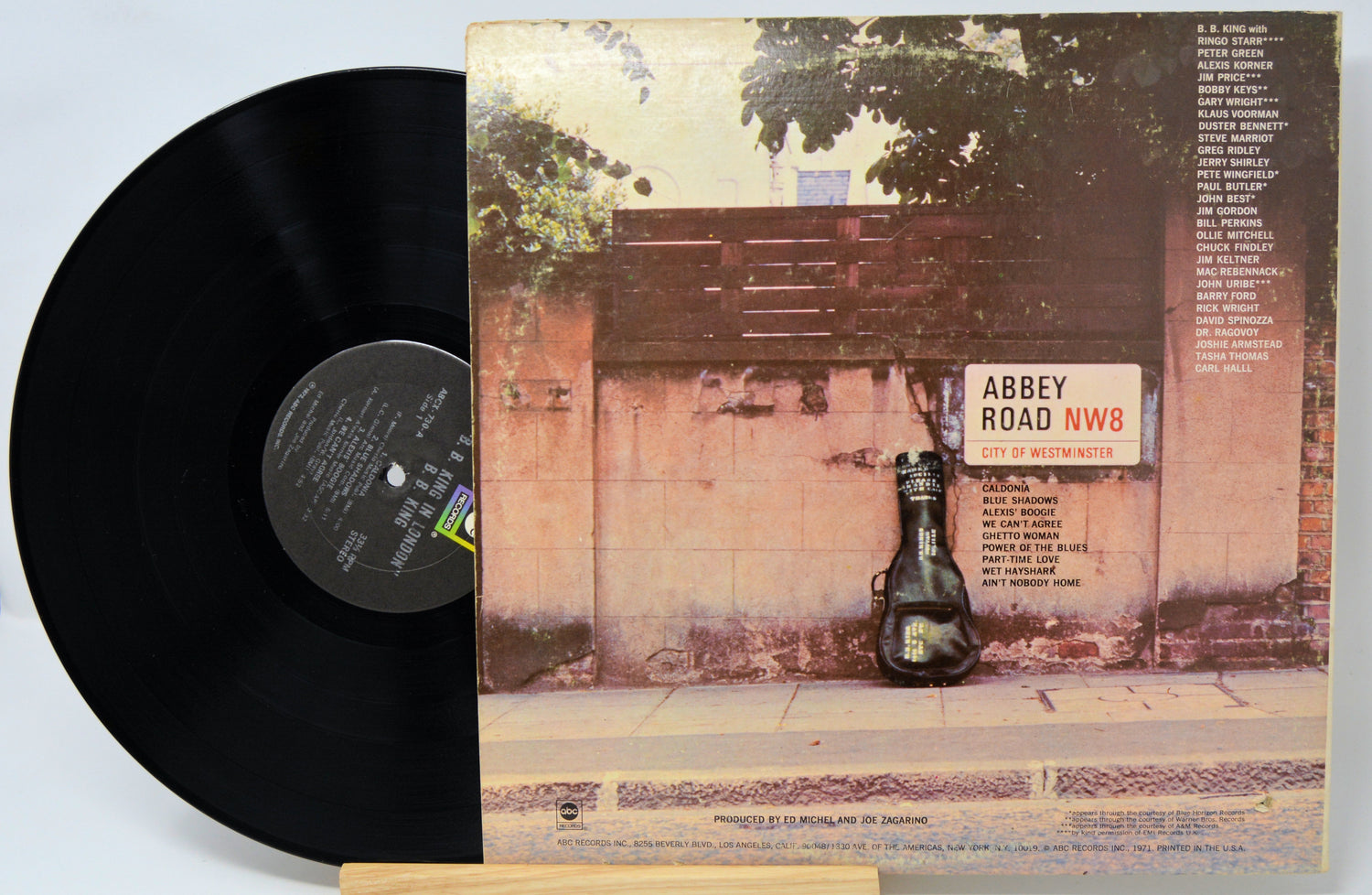 Vinyl record with cover featuring a brick wall and bottle, resembling the Abbey Road album cover.