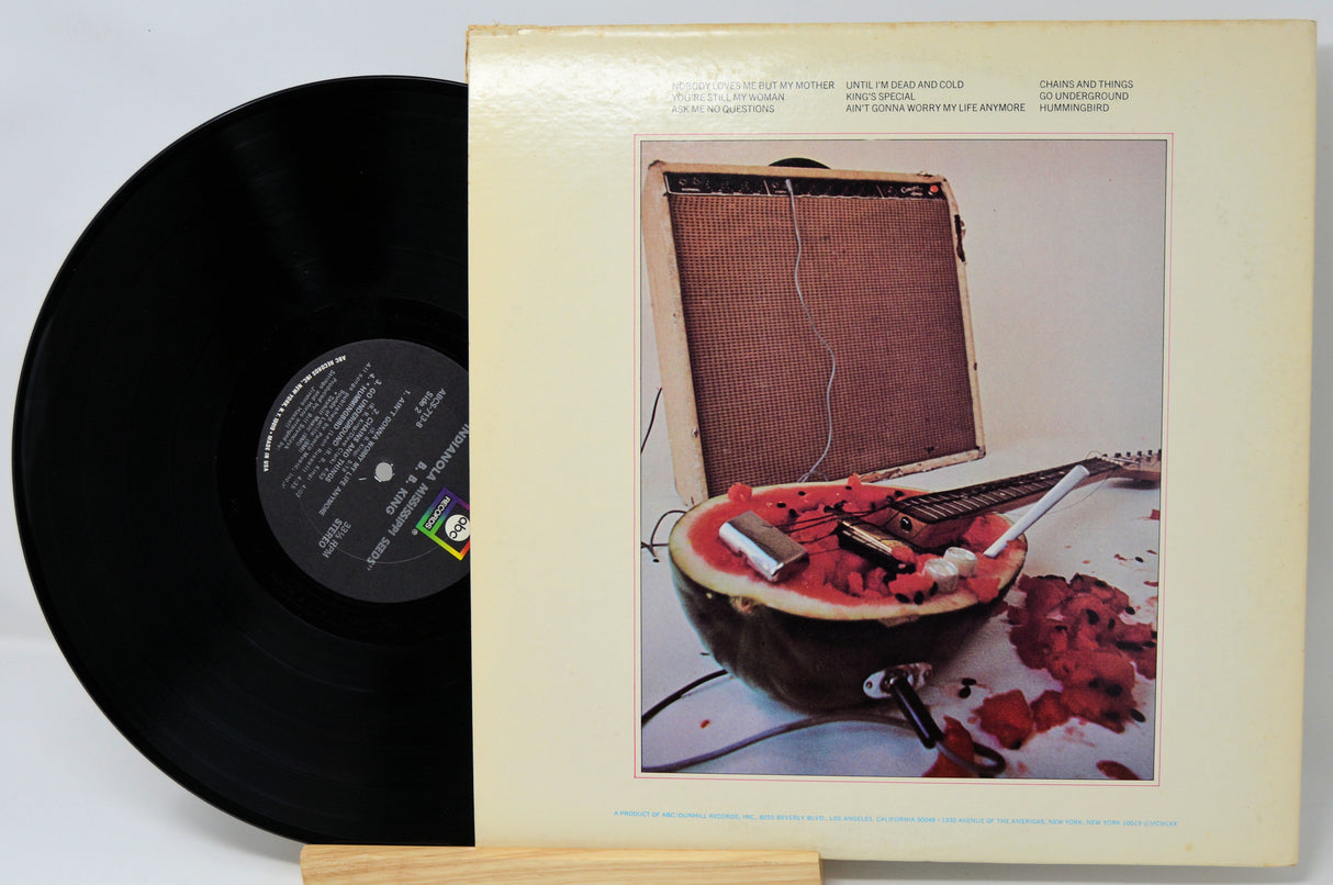 Vinyl record with a colorful album cover featuring a watermelon and amplifier.