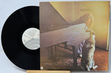 Vinyl record with a cover featuring a person and dog by a piano
