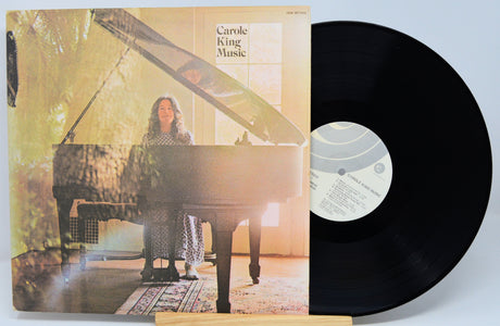 Vinyl record with cover featuring a person at a piano, on a light blue background