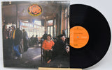 Vinyl record with cover showing a cafe scene and orange label
