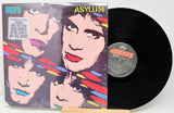 Vinyl record with 'Kiss Asylum' cover showing band members' faces.