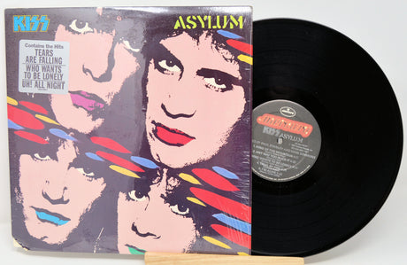 Vinyl record with 'Kiss Asylum' cover showing band members' faces.