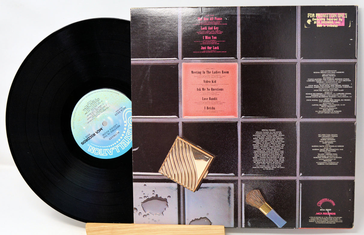 Vinyl record with a gold label and a black cover on a white background